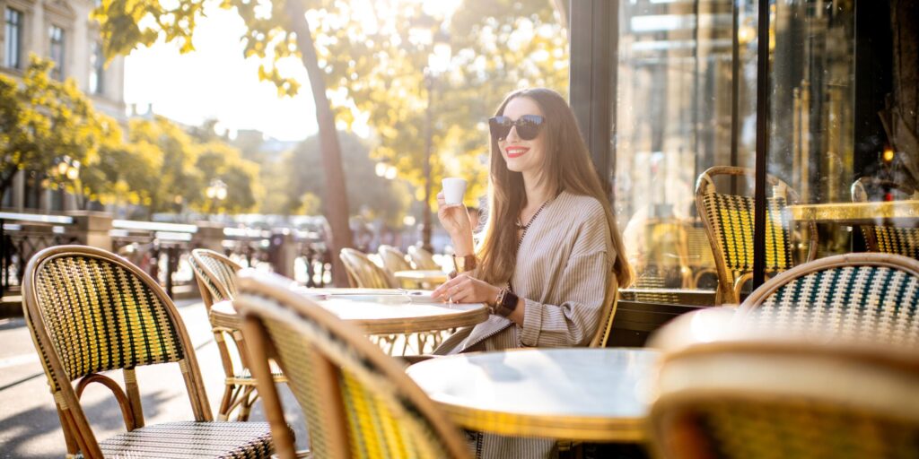 Frau sitzt draußen im französischen Café