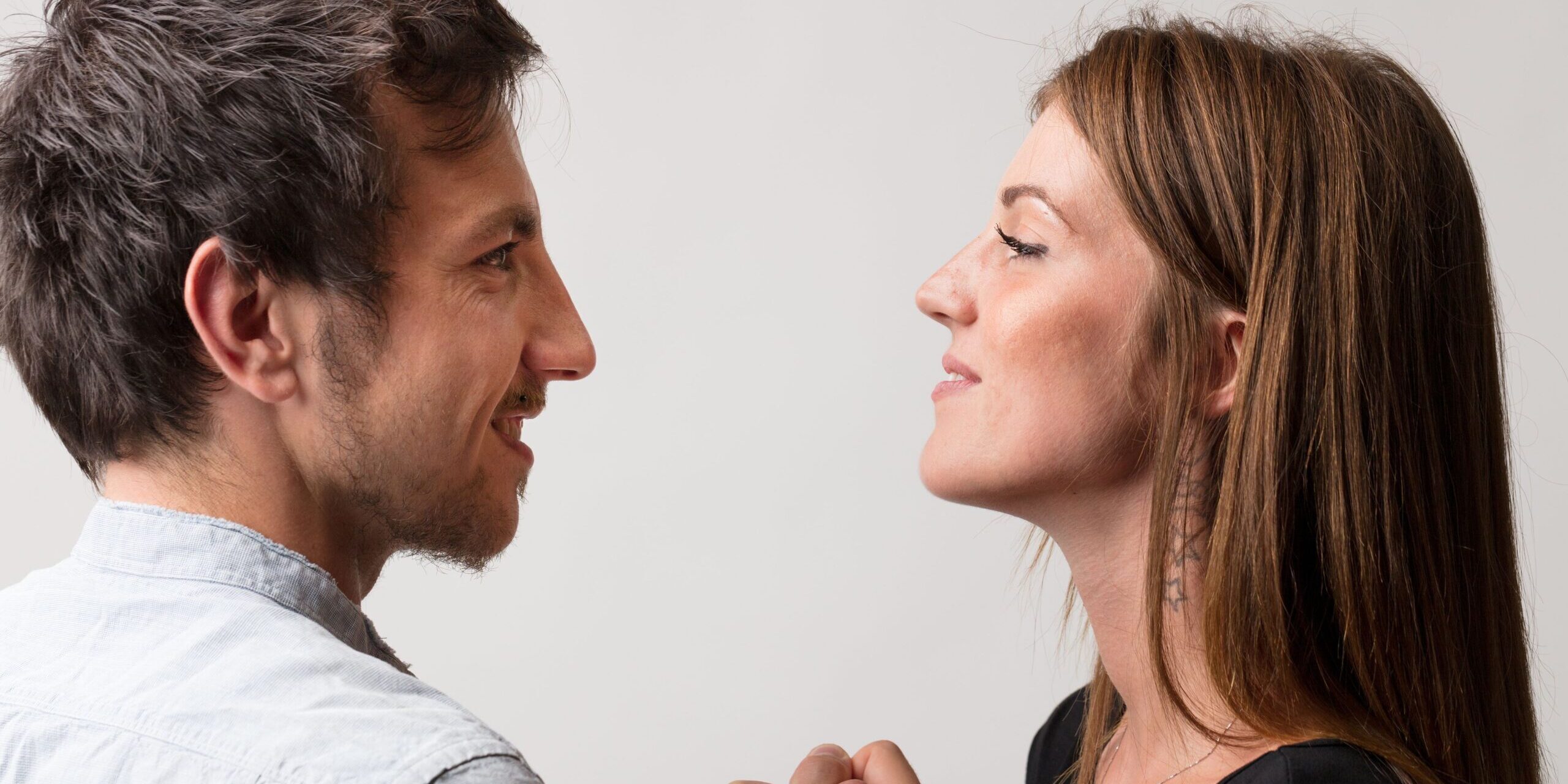 Ein Mann und eine Frau stehen sich in spielerischem Trotz gegenüber und fordern sich gegenseitig zu einem Armdrücken heraus. Sie symbolisieren Mann und Frau, sowohl als Freunde als auch als Liebhaber und Rivalen, und bewahren dabei ein Gefühl von Stolz und Spaß