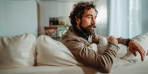 Mann sitzt auf dem Sofa und denkt intensiv nach