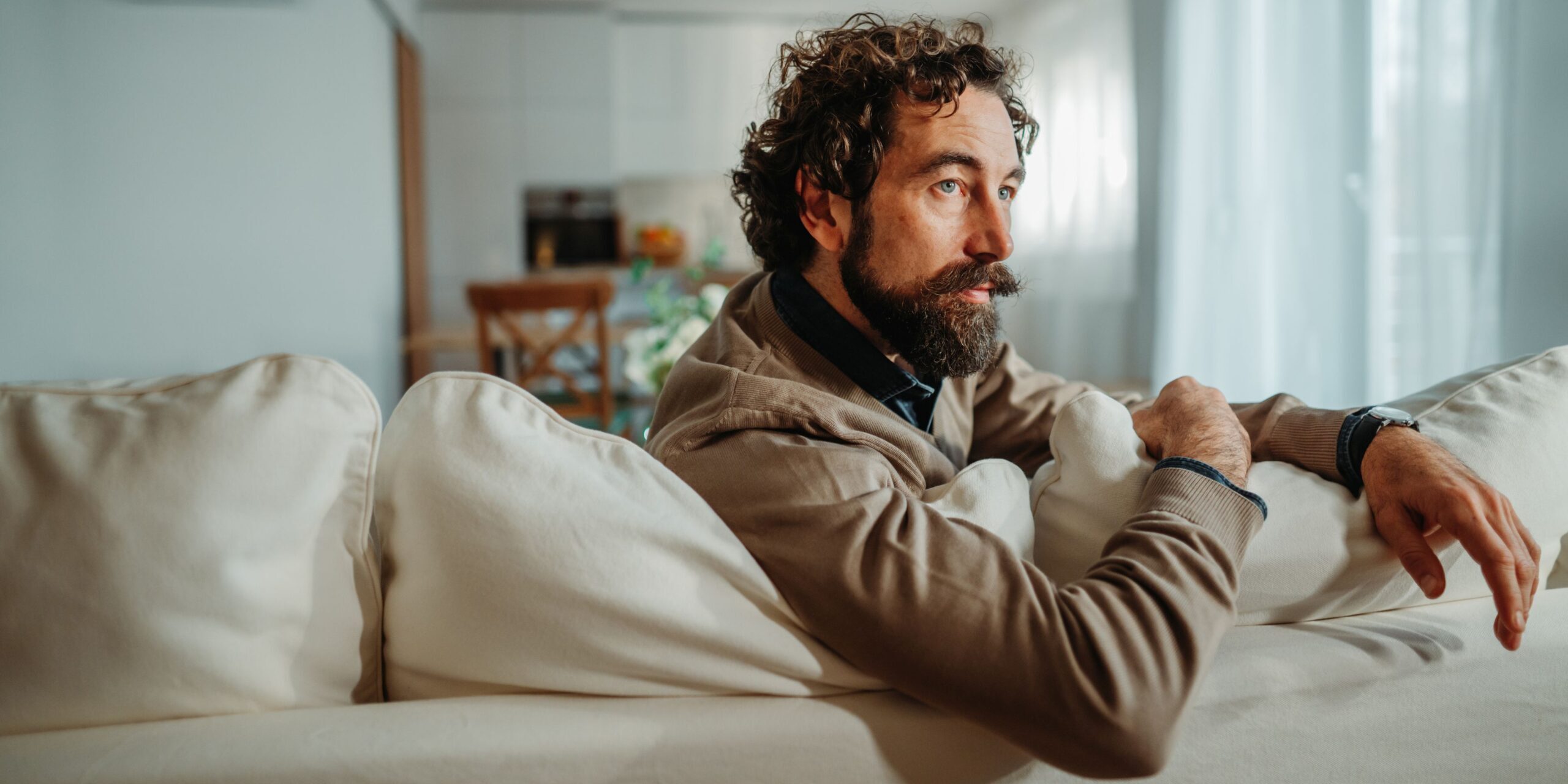 Mann sitzt auf dem Sofa und denkt intensiv nach