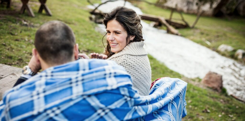 Glückliches Paar sitzt auf einer Bank in der Natur und führt gute Gespräche