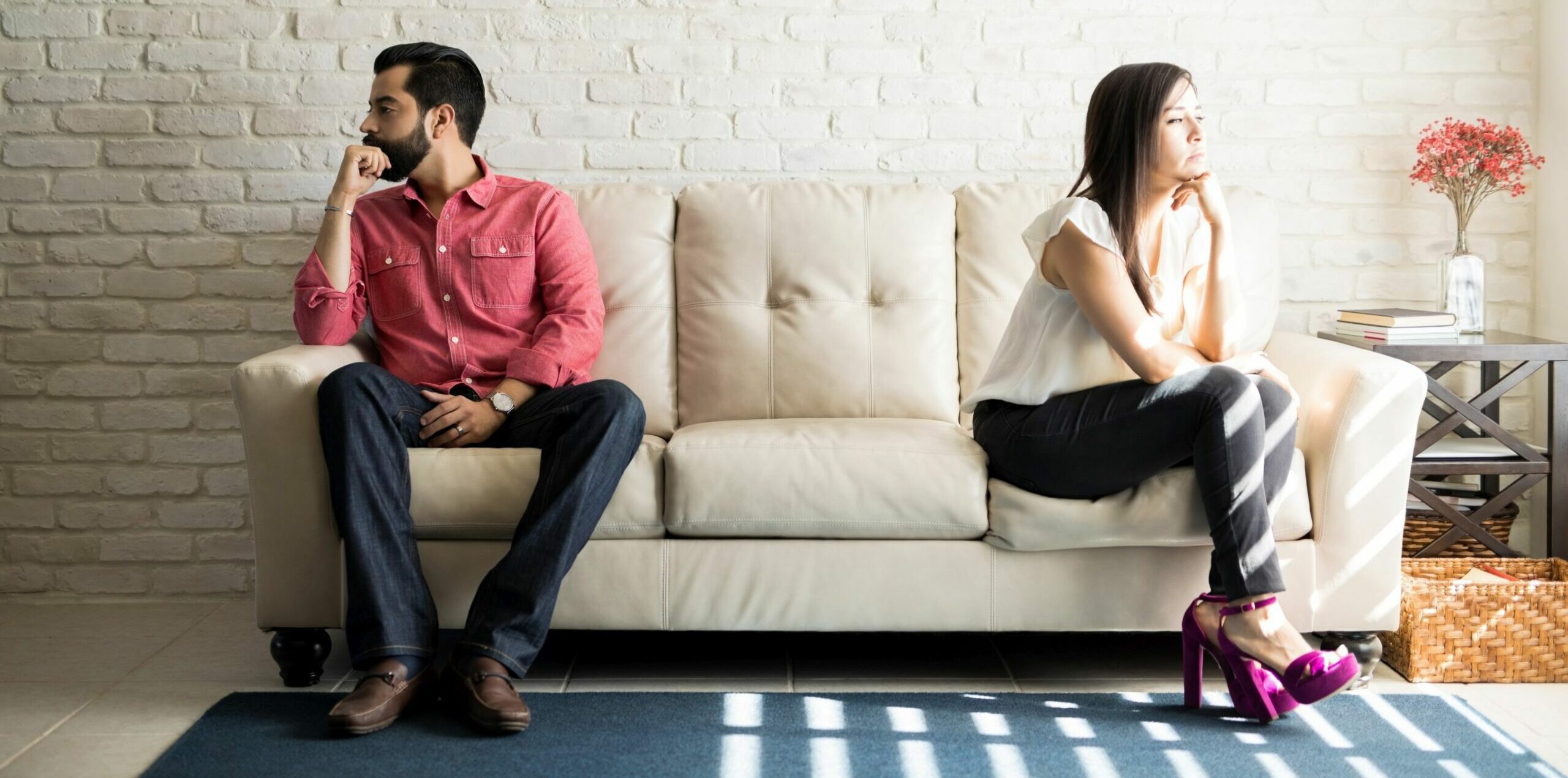 Mann und Frau sitzen nach einem Streit zu Hause auf der Couch und reden nicht