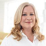 Headshoot von Silke Setzkorn vor hellem Hintergrund, klein