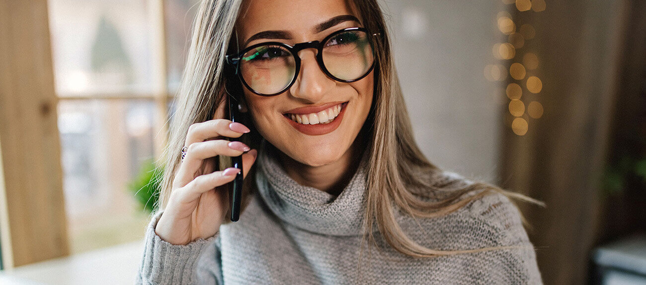 30 jährige Frau telefoniert mit ihrem Online-Beziehungscoach und lacht beim dem Gespräch